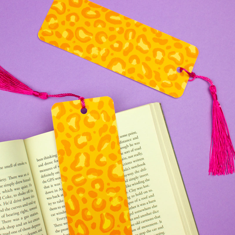 Sprinkle Club - A bright orange bookmark with a leopard print design, finished with a vivid pink tassel